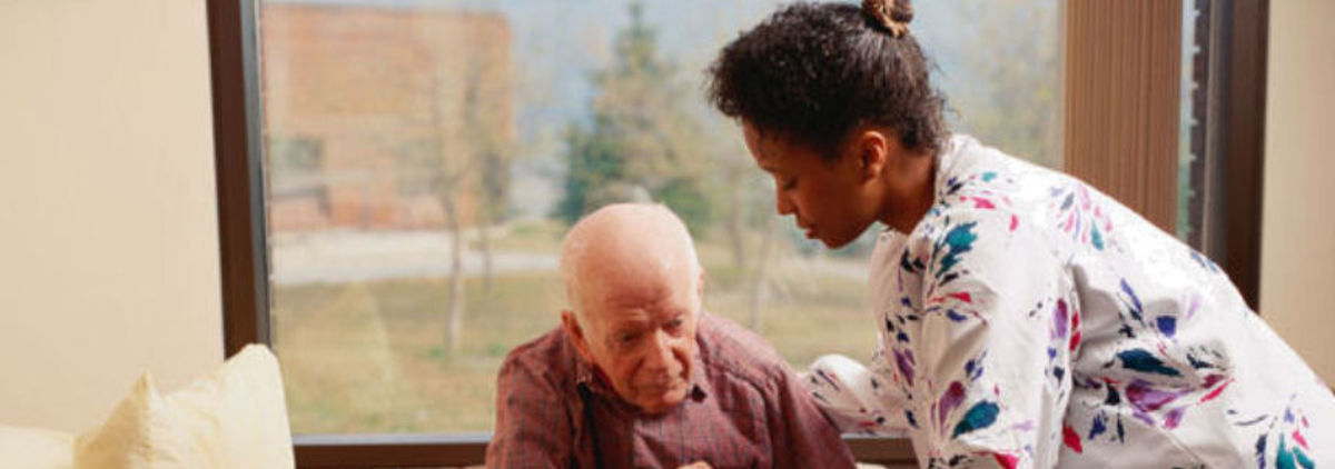 Carer helping elderly man