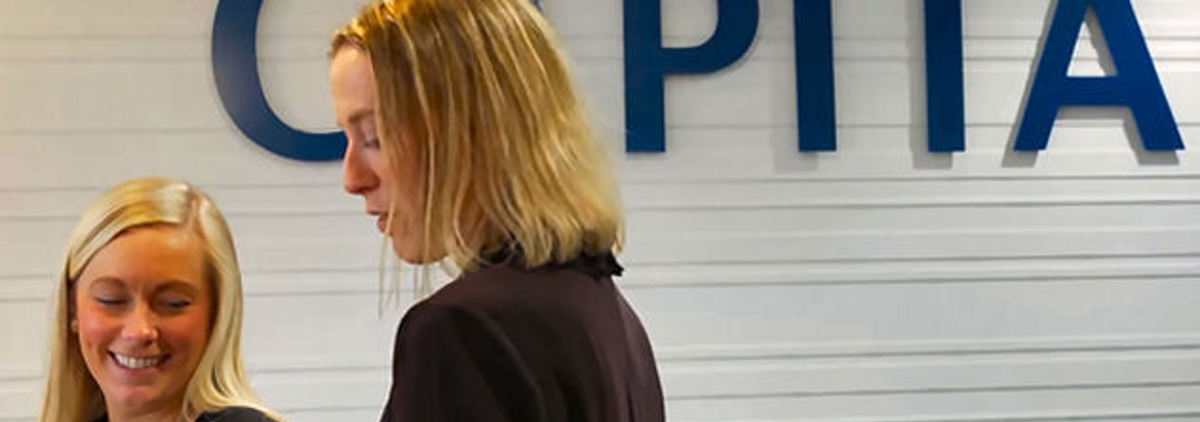Capita sign and women