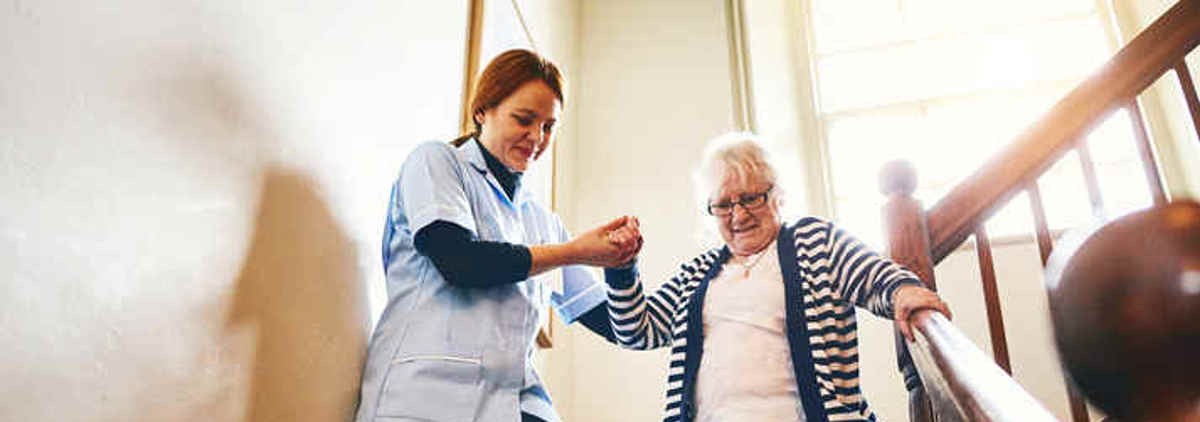 Carer and woman going down stairs